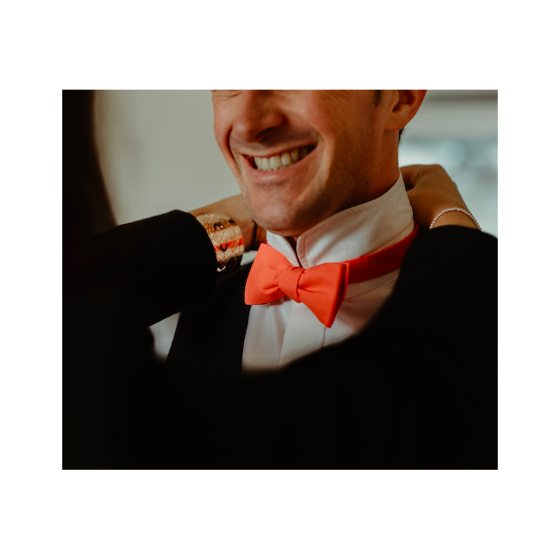 black suit with coral bow tie